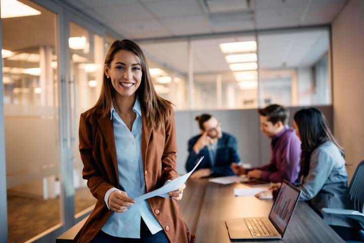 Gender pay gap: immagine di donna sorridente in ufficio